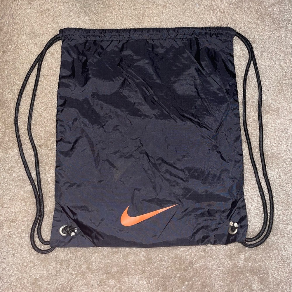 Nike soccer string bag, with a cool zipper pocket inside, lettering is orange